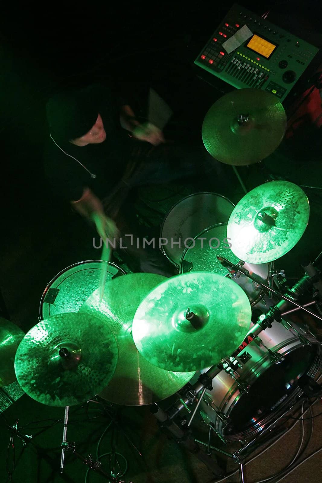 drummer in shadow, drums lighted with green colour