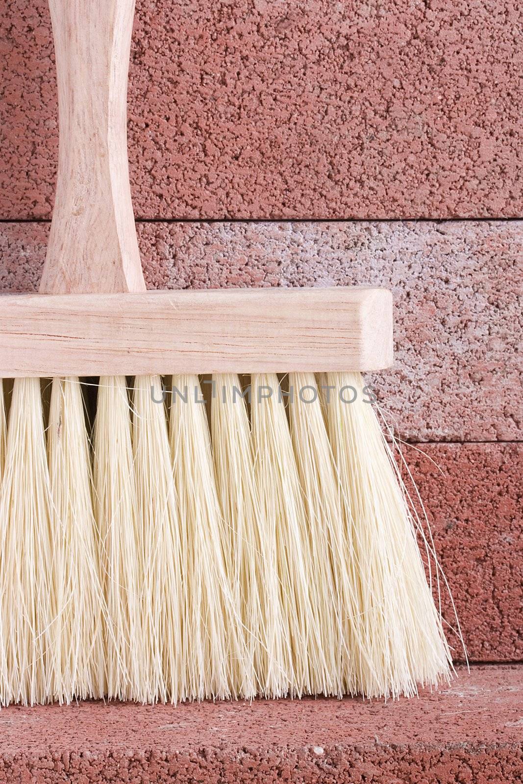 Stonemason's brush on a background of red bricks.