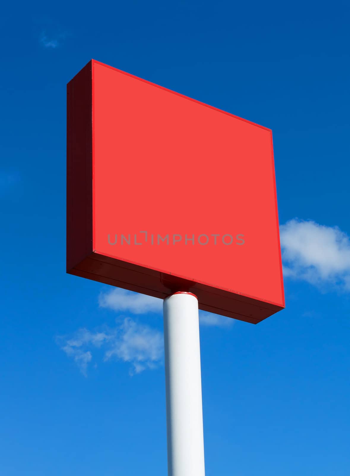 Red blank billboard on a sunny day with blue sky