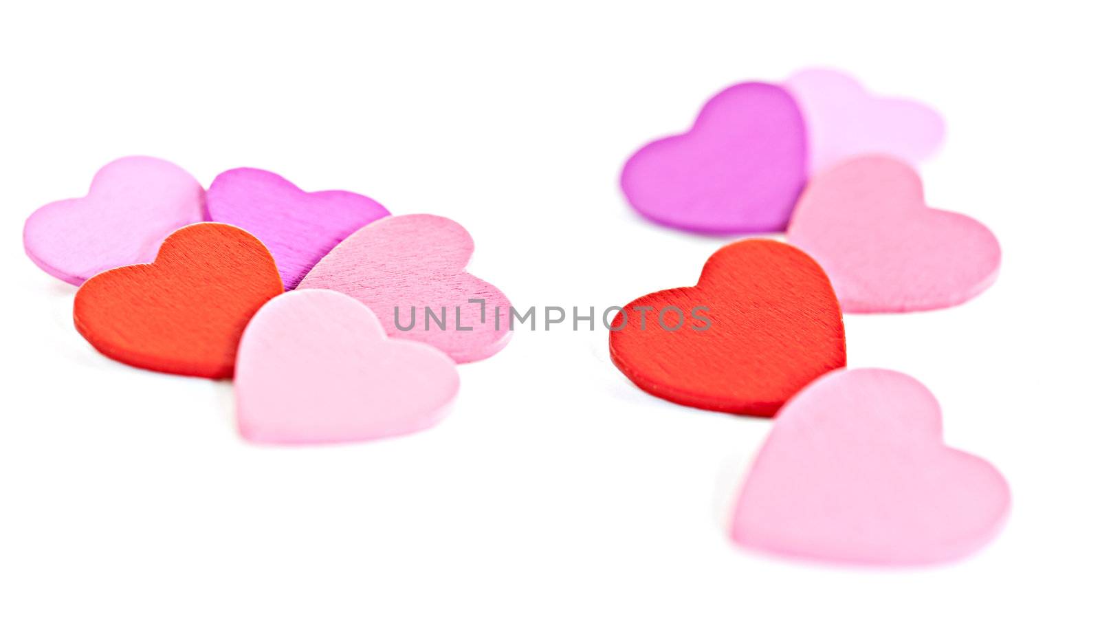Colorful wooden pegs with a heart on a white background. Macro photography.
