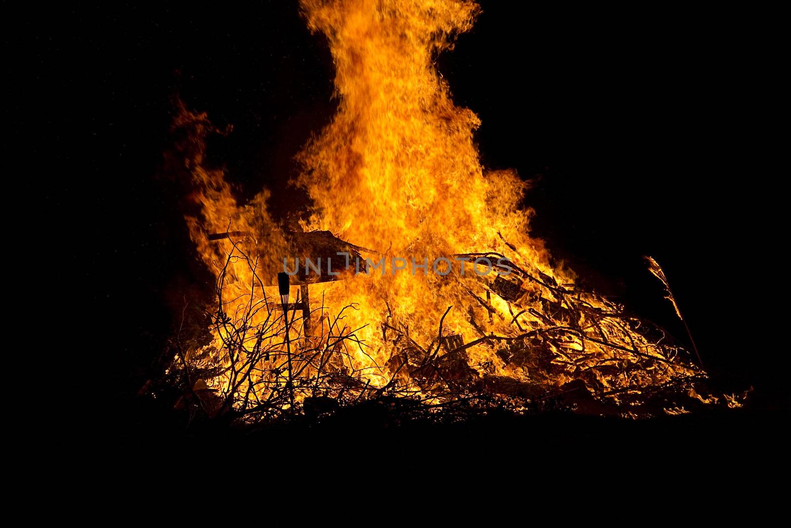 mountiain of debris burning with intensity in the night