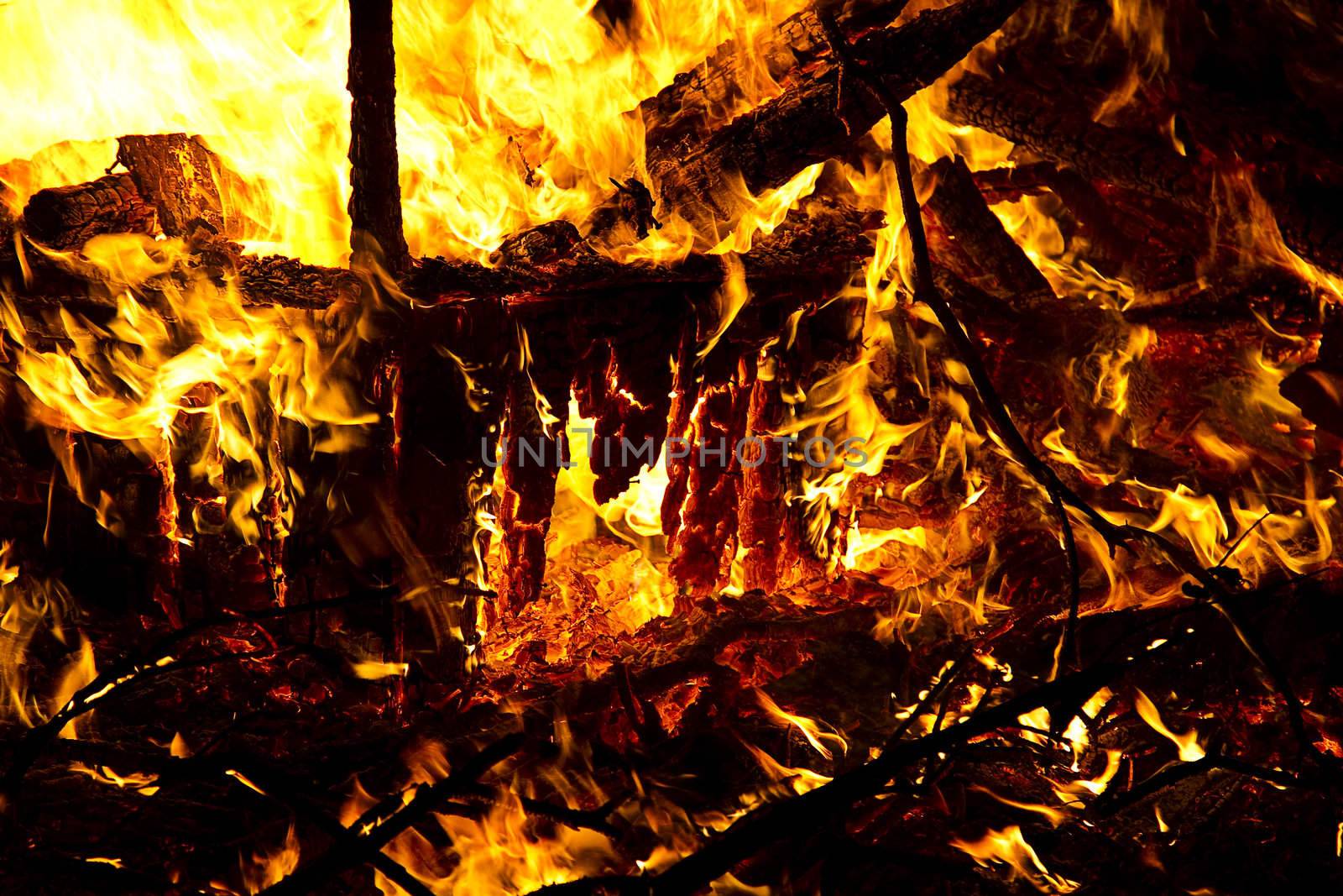 mountiain of debris burning with intensity in the night