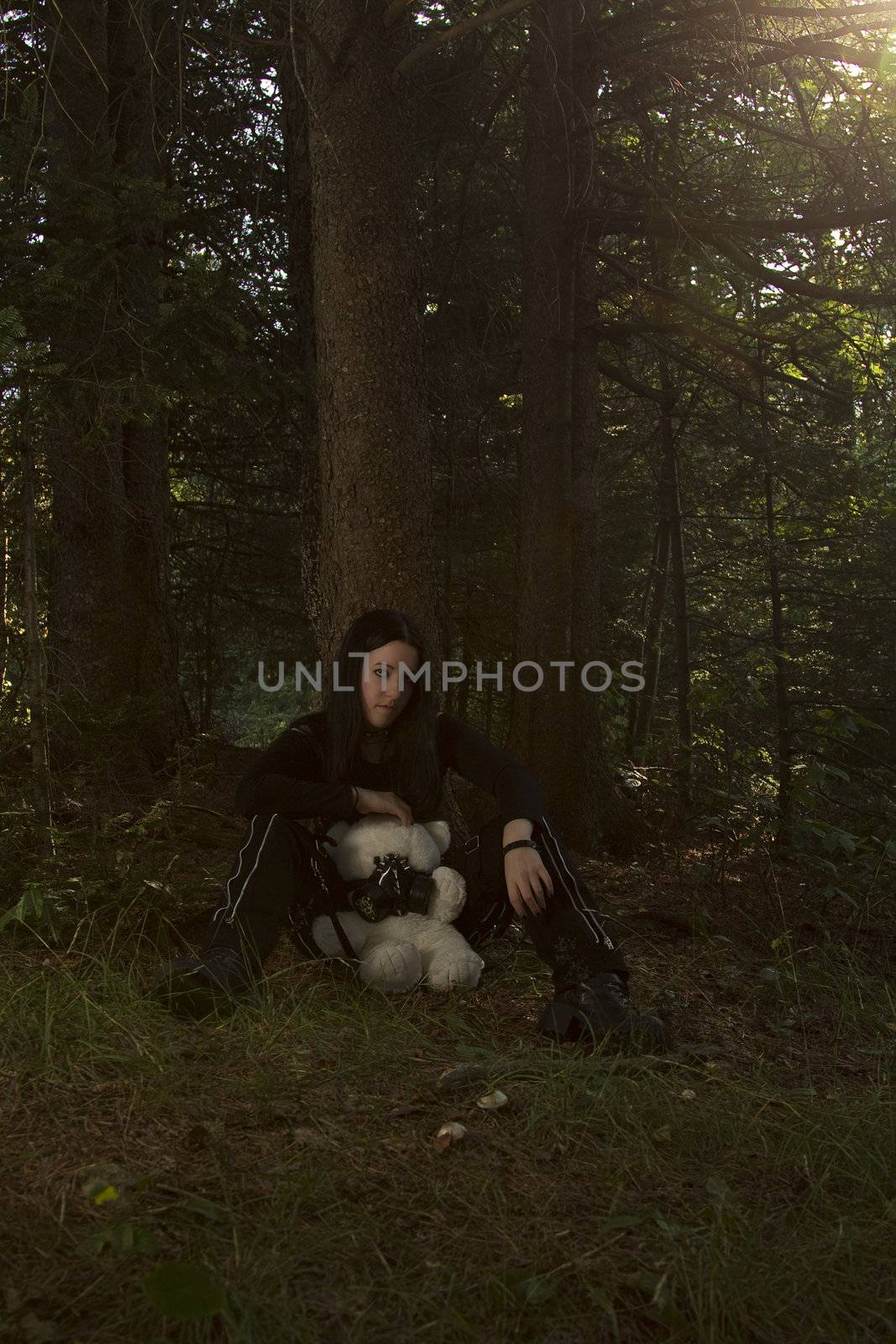 black and white portrait of a twenty something girl dress in goth fashion with a white teddy bear wearing a gaz mask, while being scared lost in the woods