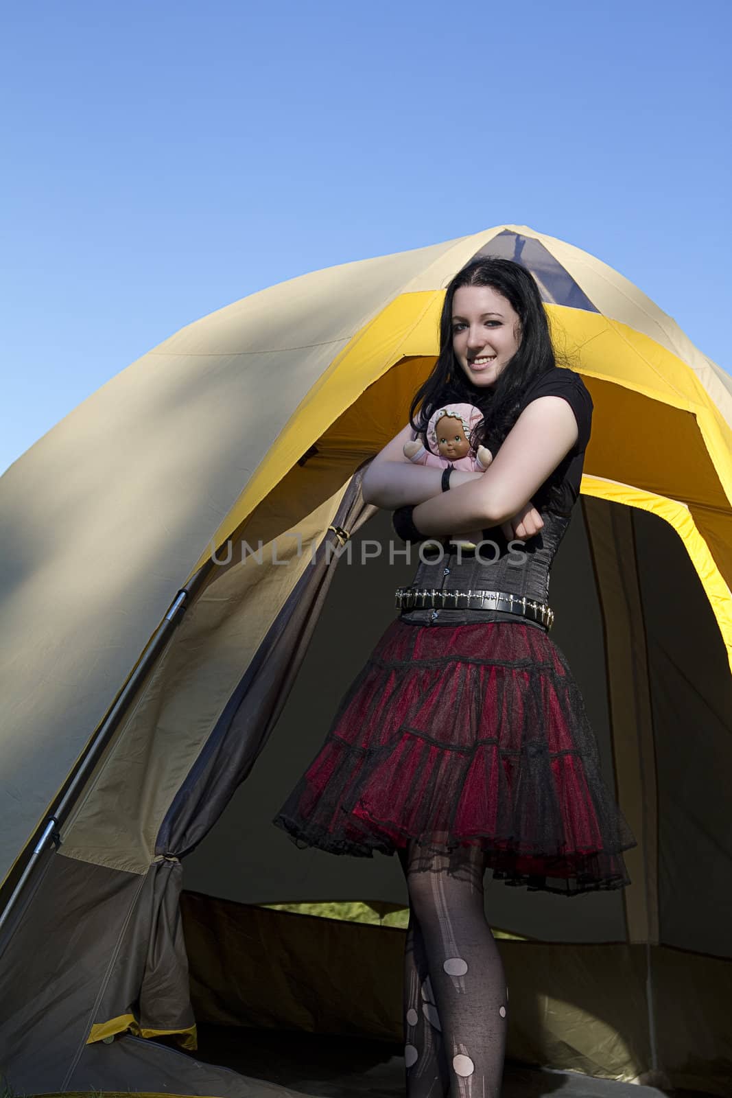 twenty something women wearing goth style clothes and holding a small baby doll
