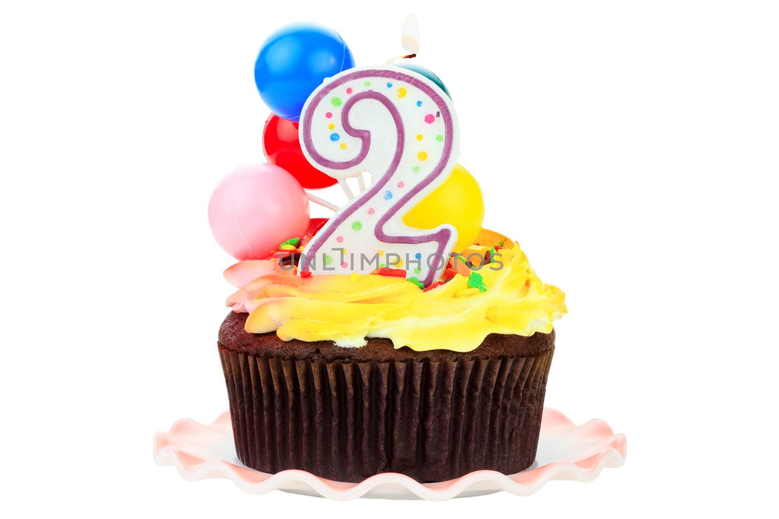 Chocolate birthday cake with number  two candle and plastic balloons. Isolated on a white background.