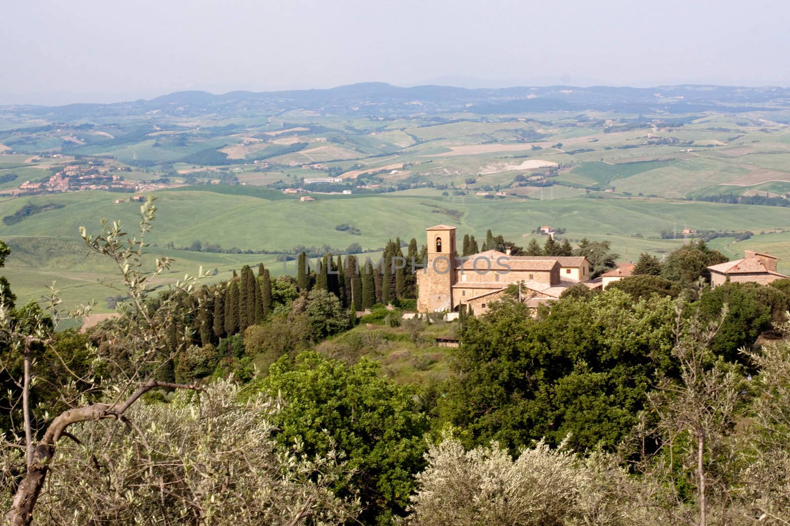 A medieval building and trees in Tuskanian hills
