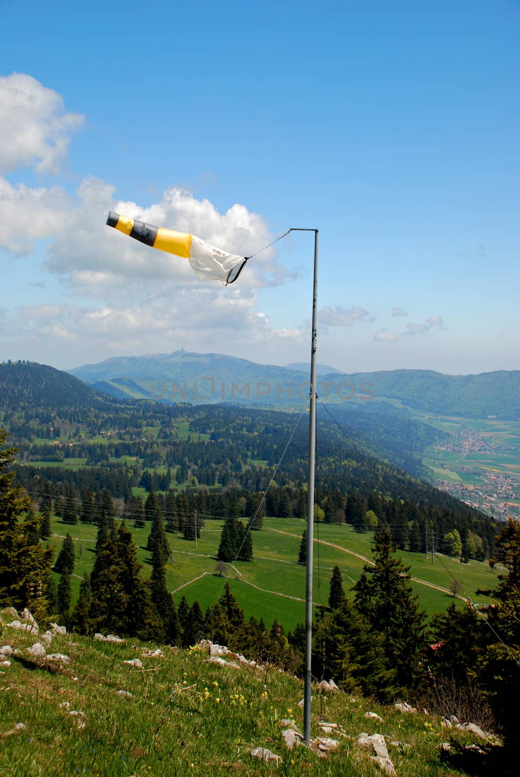 Wether-cock on Tete de Ran meteo station showing the wind dirrection, Jura hills and the sky is at background