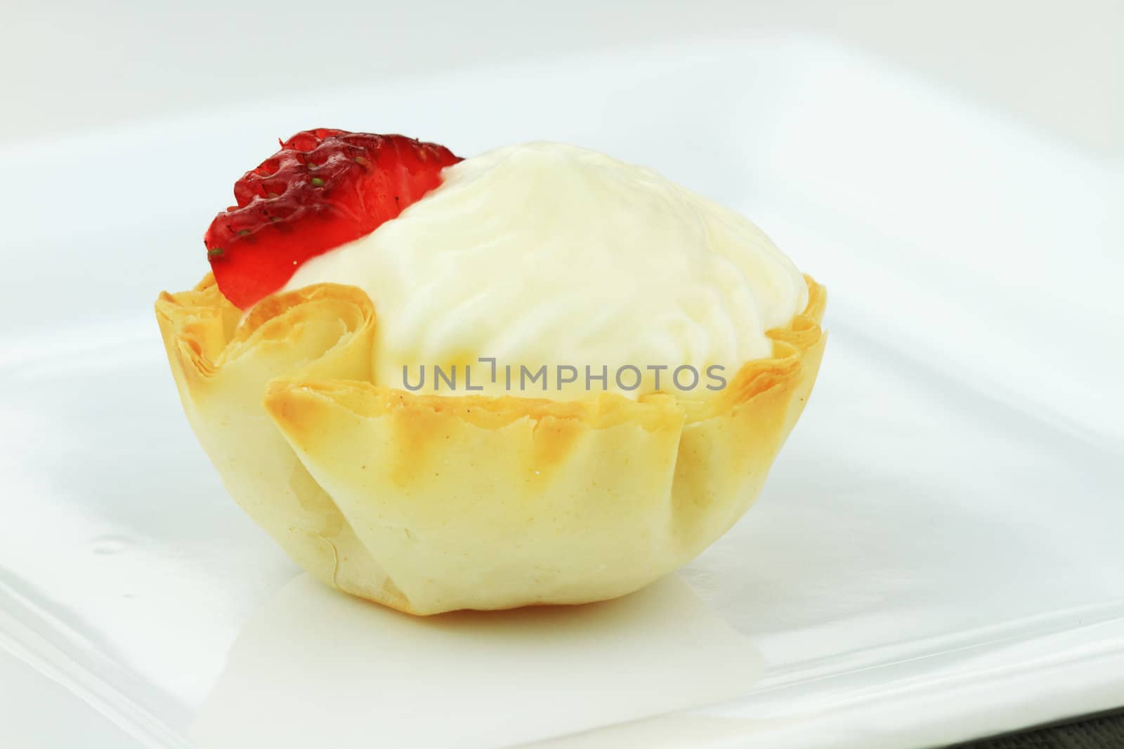 Cream cheese tart with a slice of strawberry.