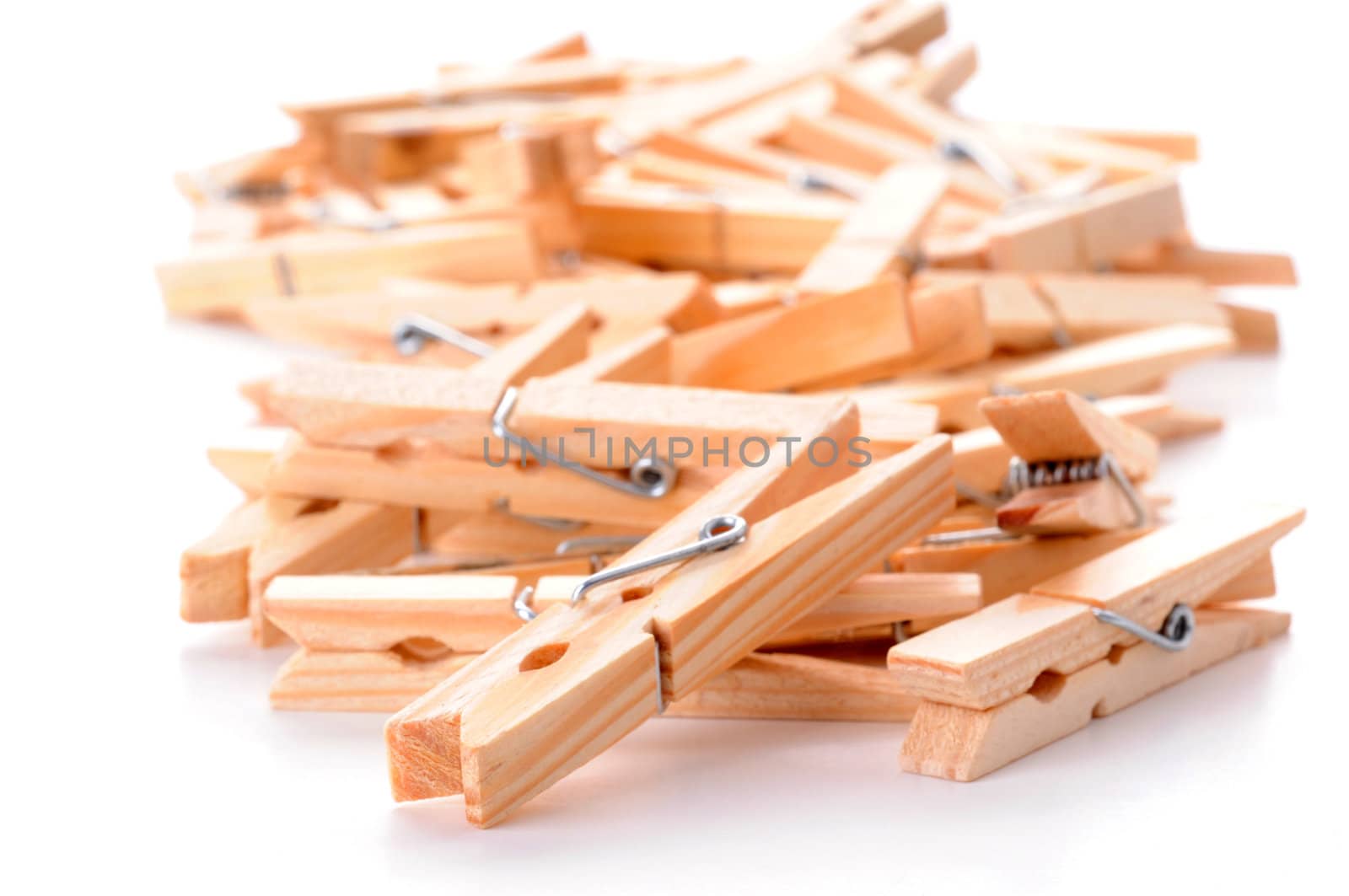 Pile of wooden clothespins on a white background.