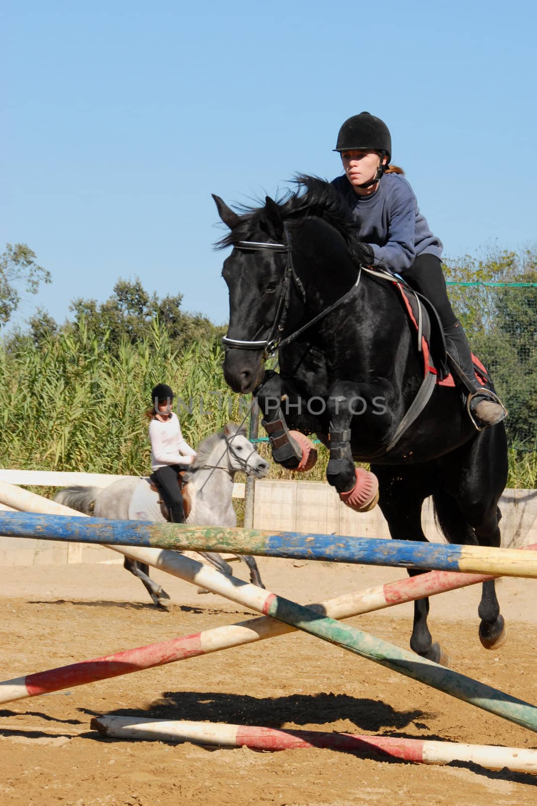 jumping yound woman and her black stallion
