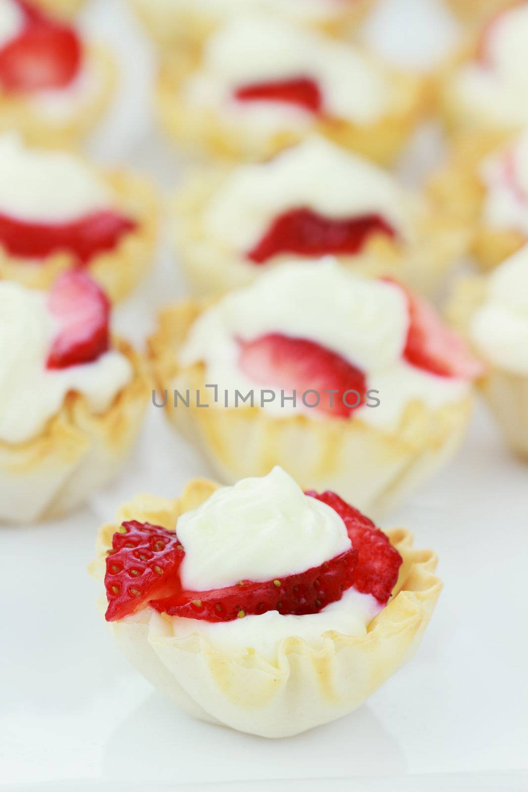 Cream cheese tarts with a slices of strawberry.