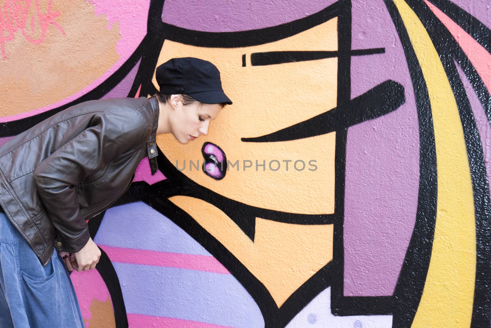 Young woman posing in front of a graffiti