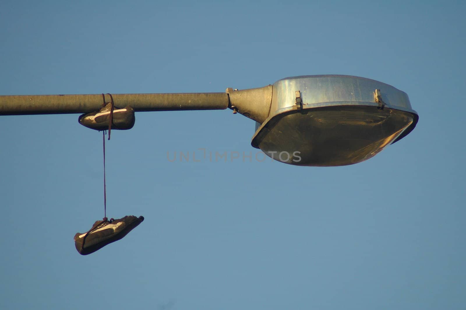 detail of street lamp and shoes hanging on it