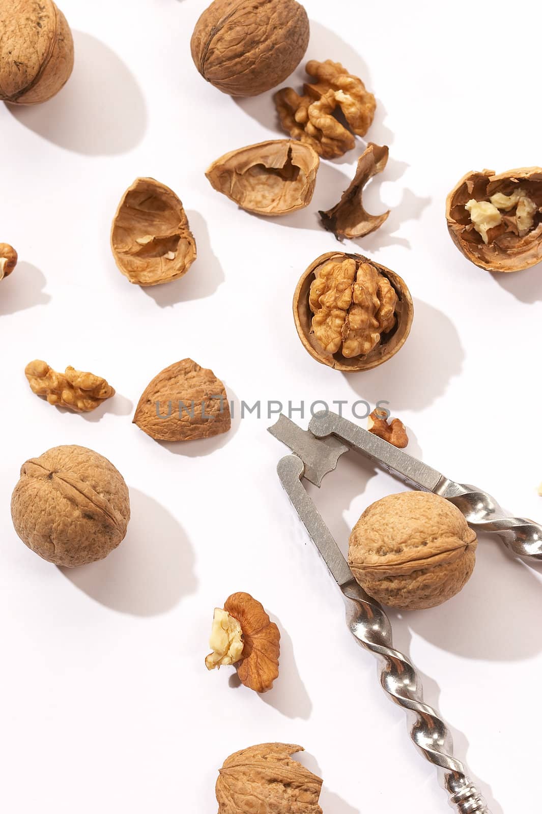 some walnuts and nutcrackers over white