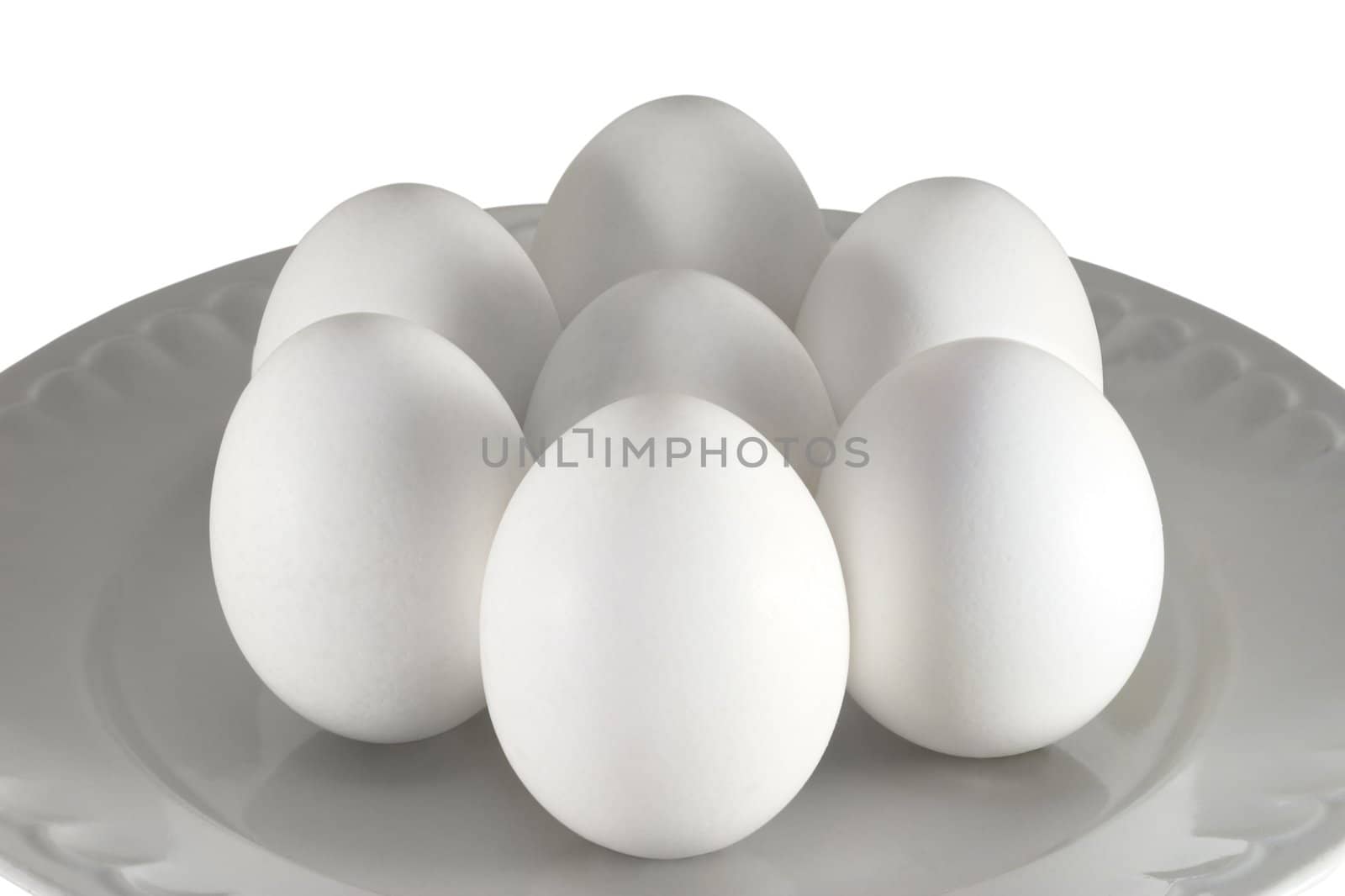 White chicken eggs in a plate on a white background