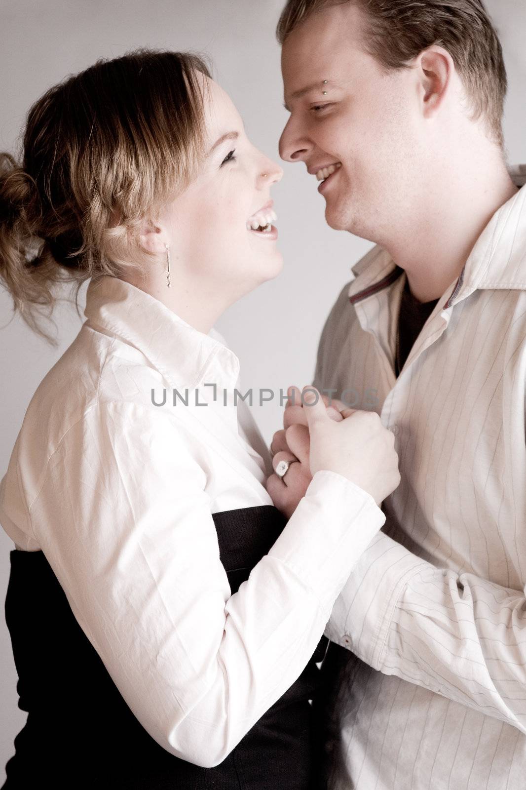 Studio portrait of a young amorous couple laughing