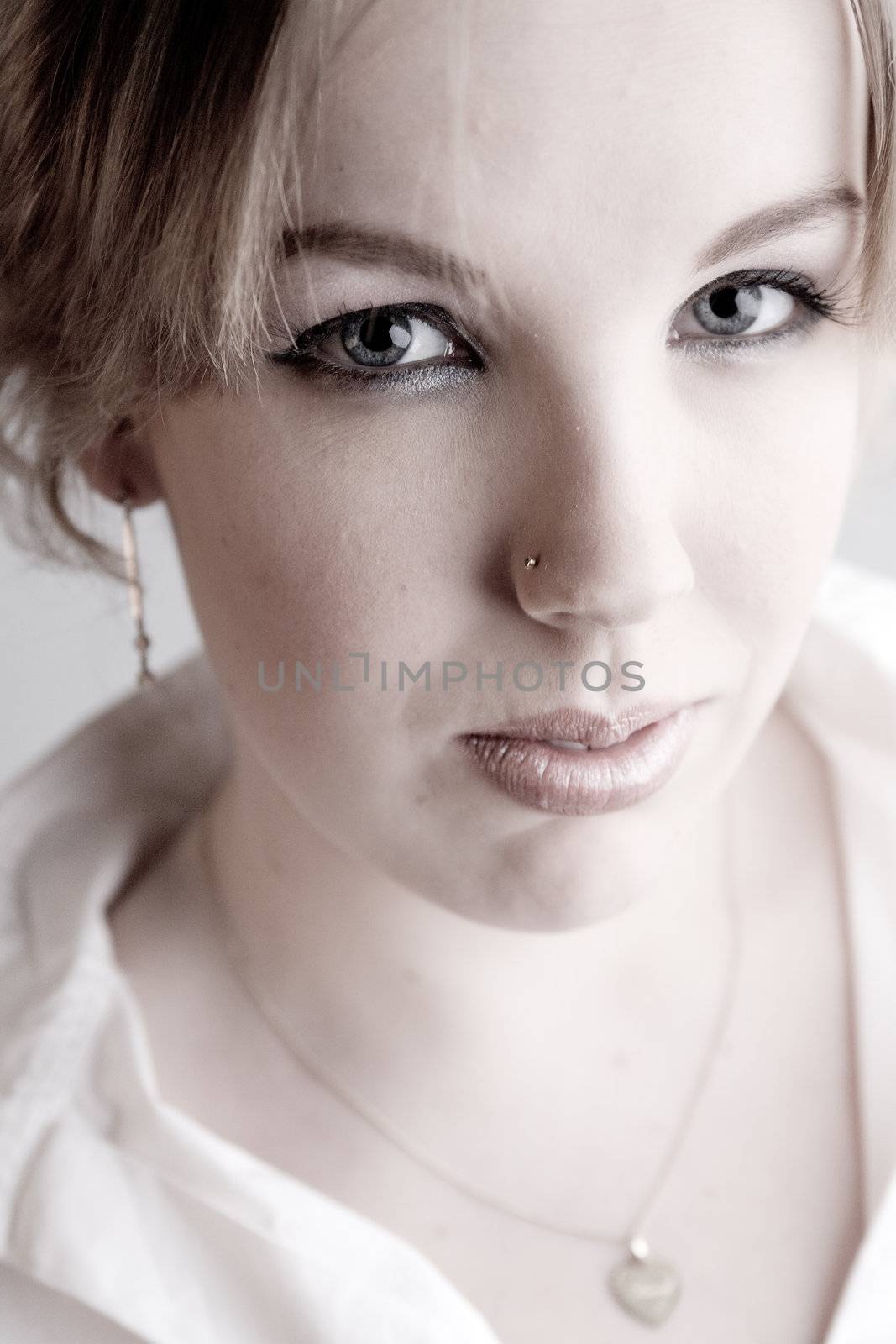 Studio portrait of a young blond curly woman with a hypnothizing look