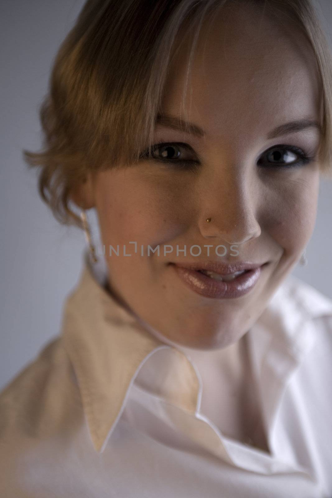 Studio portrait of a young blond curly woman looking cute