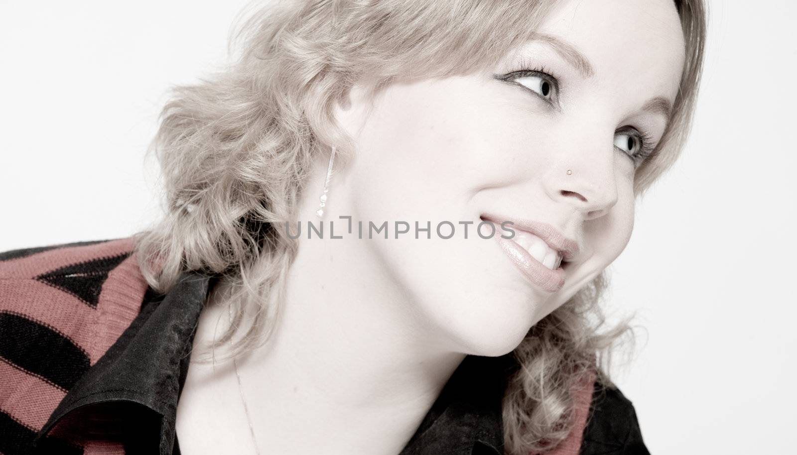 Studio portrait of a young blond curly woman looking dreamy