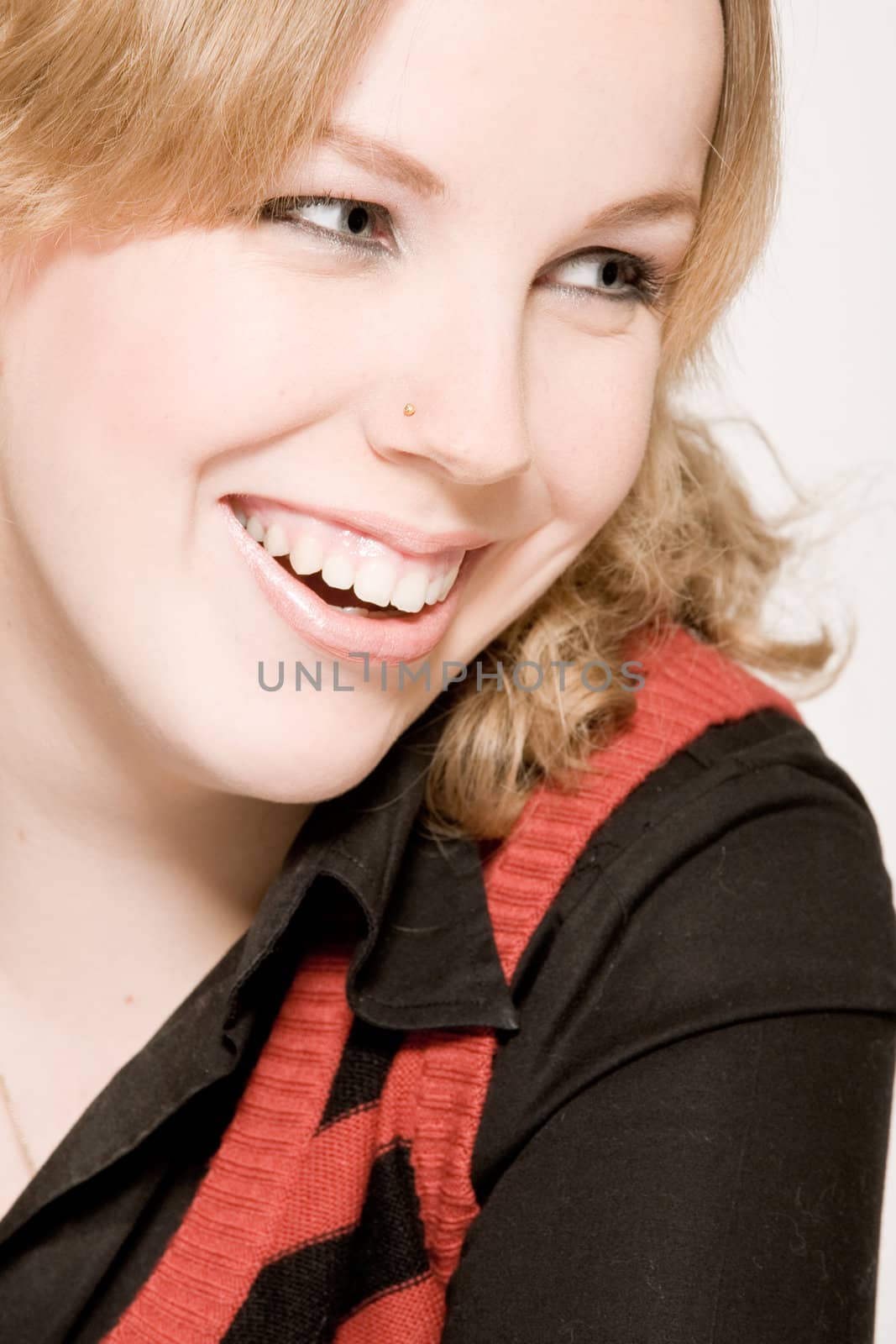 Studio portrait of a young blond curly woman laughing