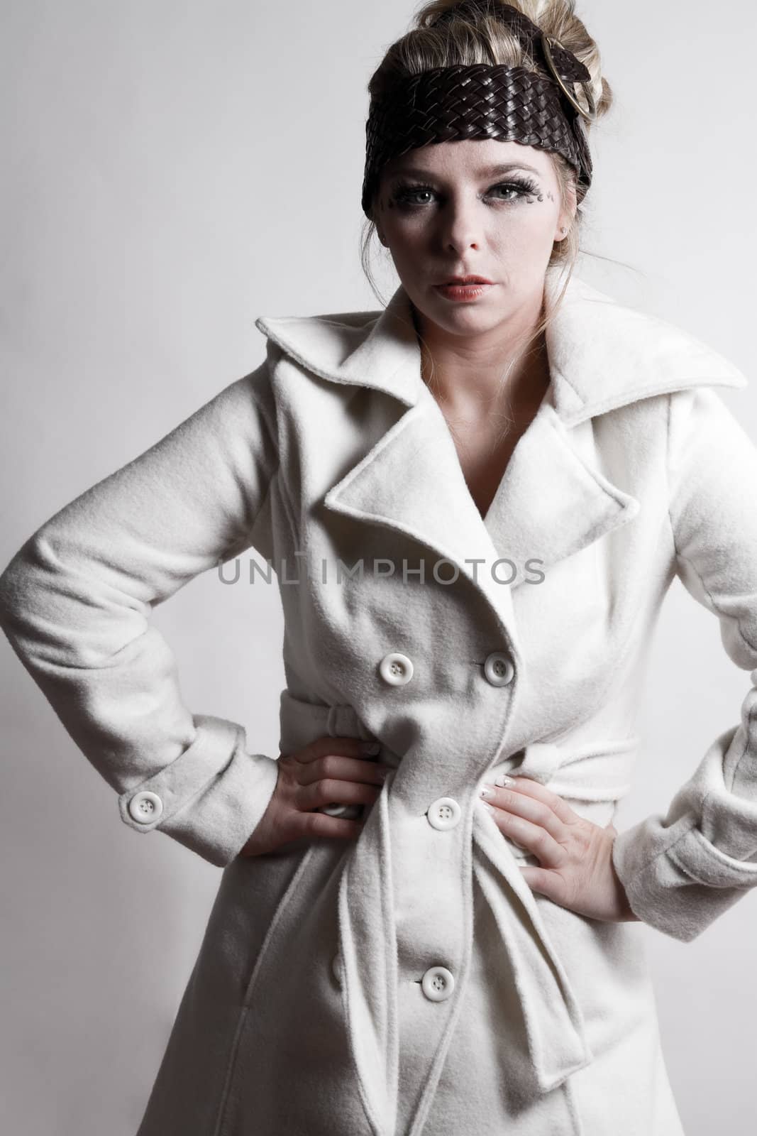 Studio fashion portrait of a young bliond girl showing of her small waist