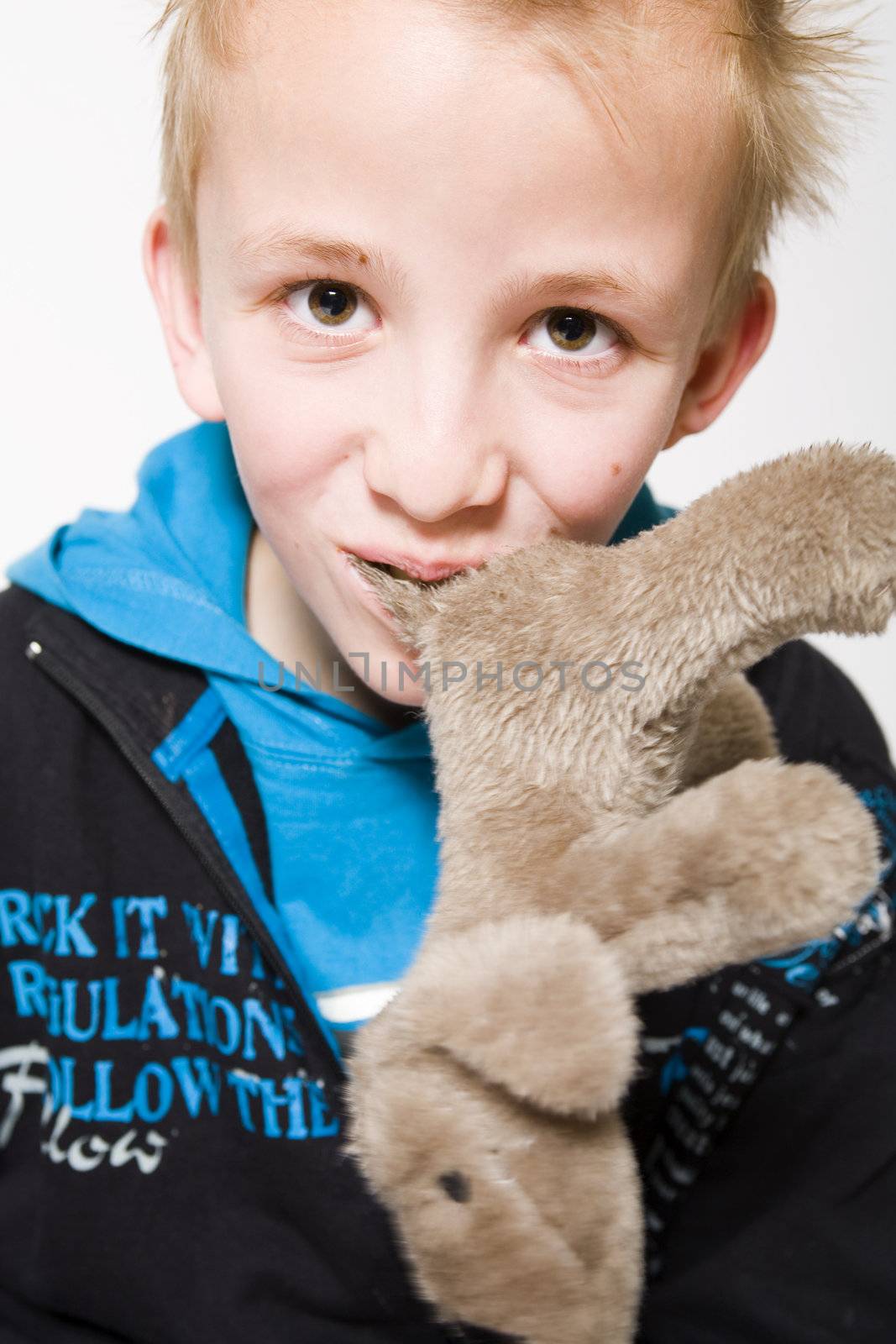 A young boy with a furry toy in his mouth