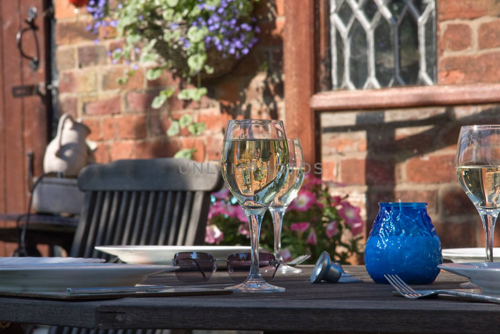 Wine glass reflects a beautiful sunny garden.