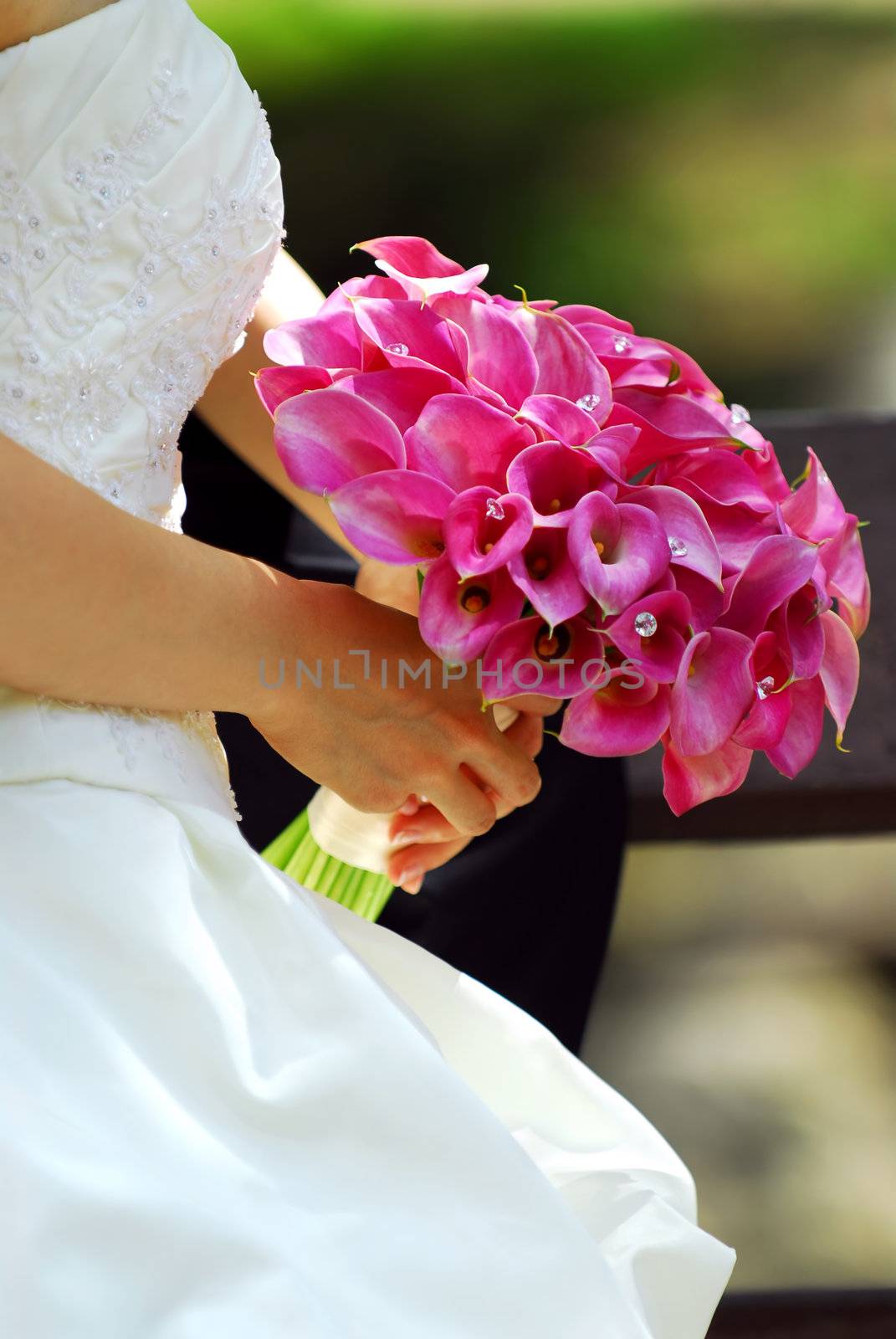 Bride in wedding gown holding bouquet of pink flowers