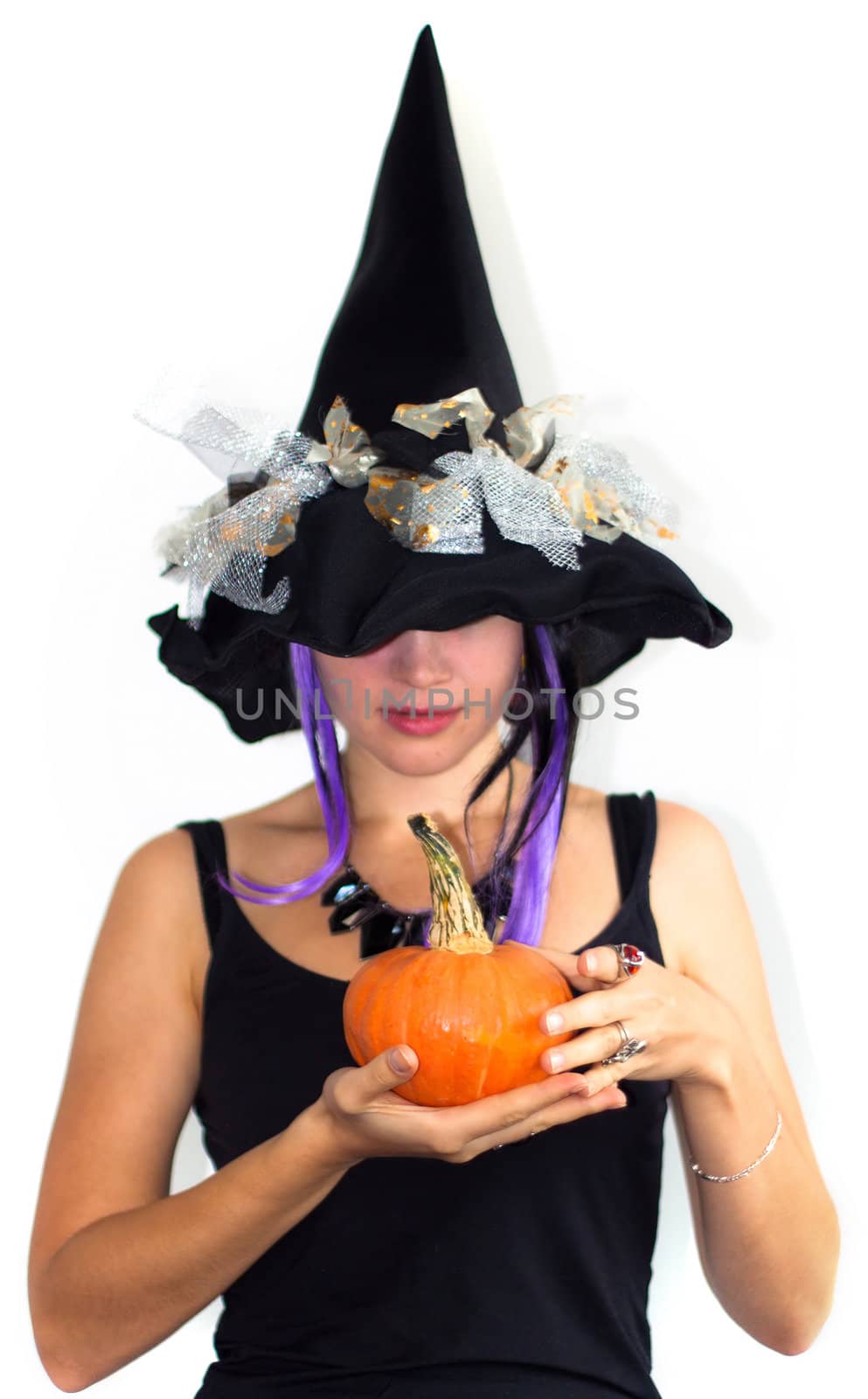 Young pretty witch with small pumpkin