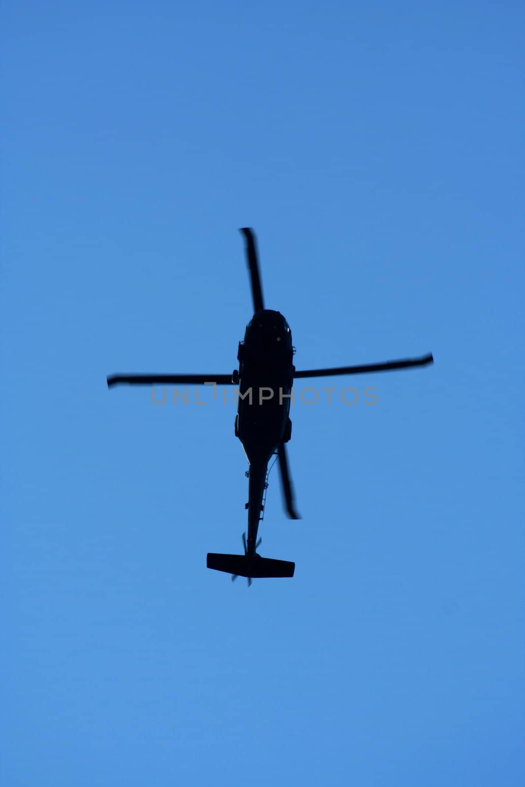A helicopter silhouette aginst blue sky