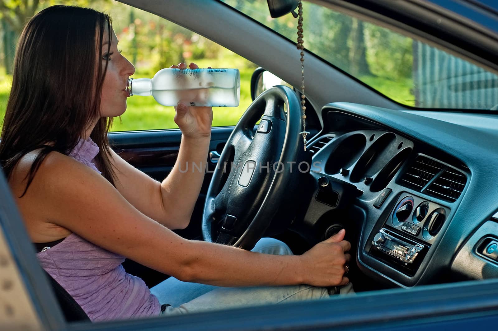 Woman drinking alcohol during a drive in a car