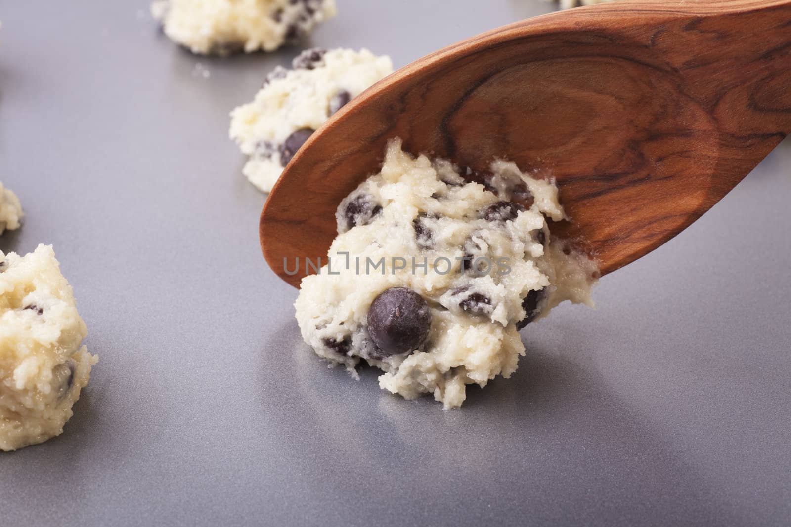 Cookie dough being placed on cookie sheet.