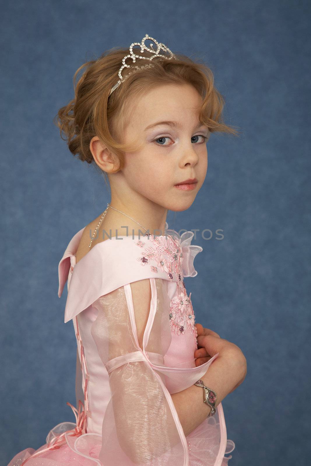 Little girl in fashionable dress on a blue background