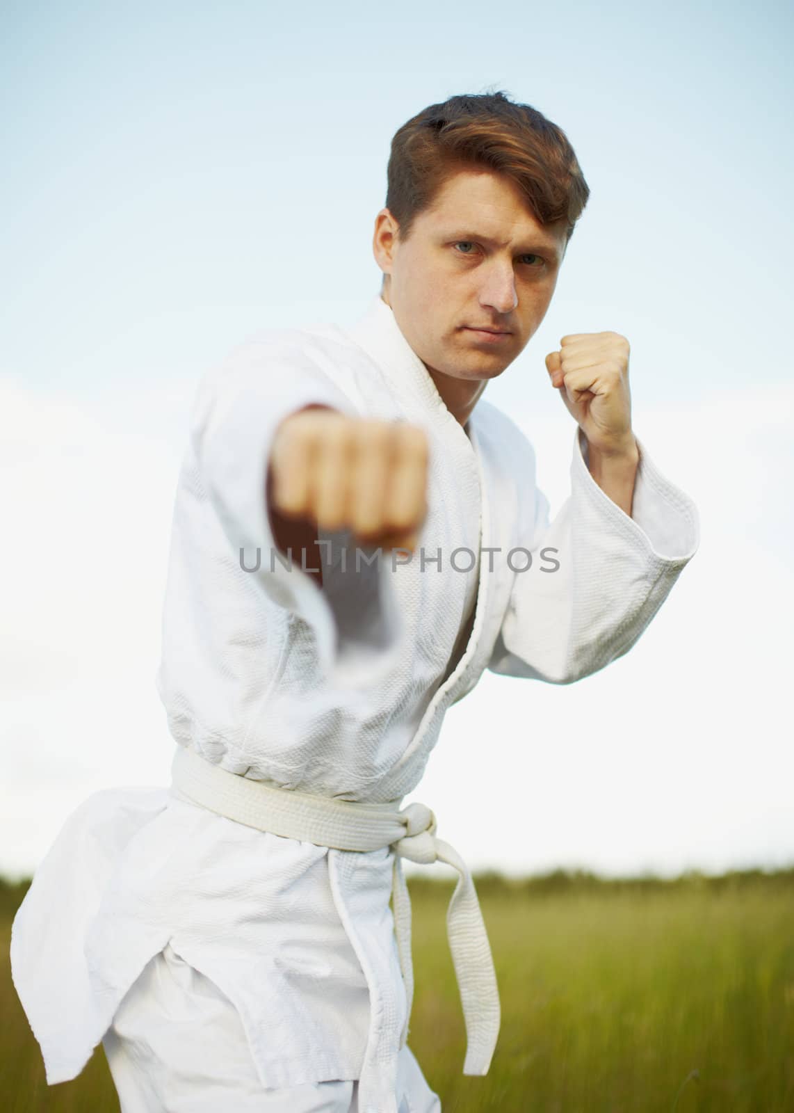 The young man is engaged in karate open-air