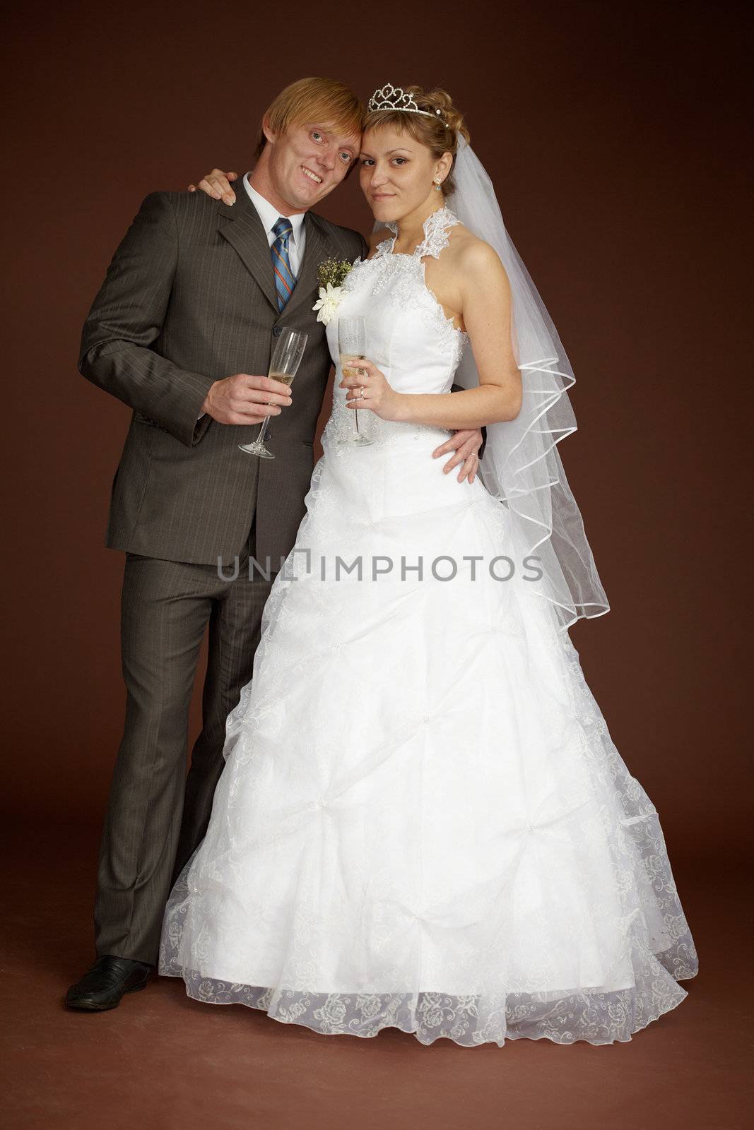 The bride and groom together on a brown background