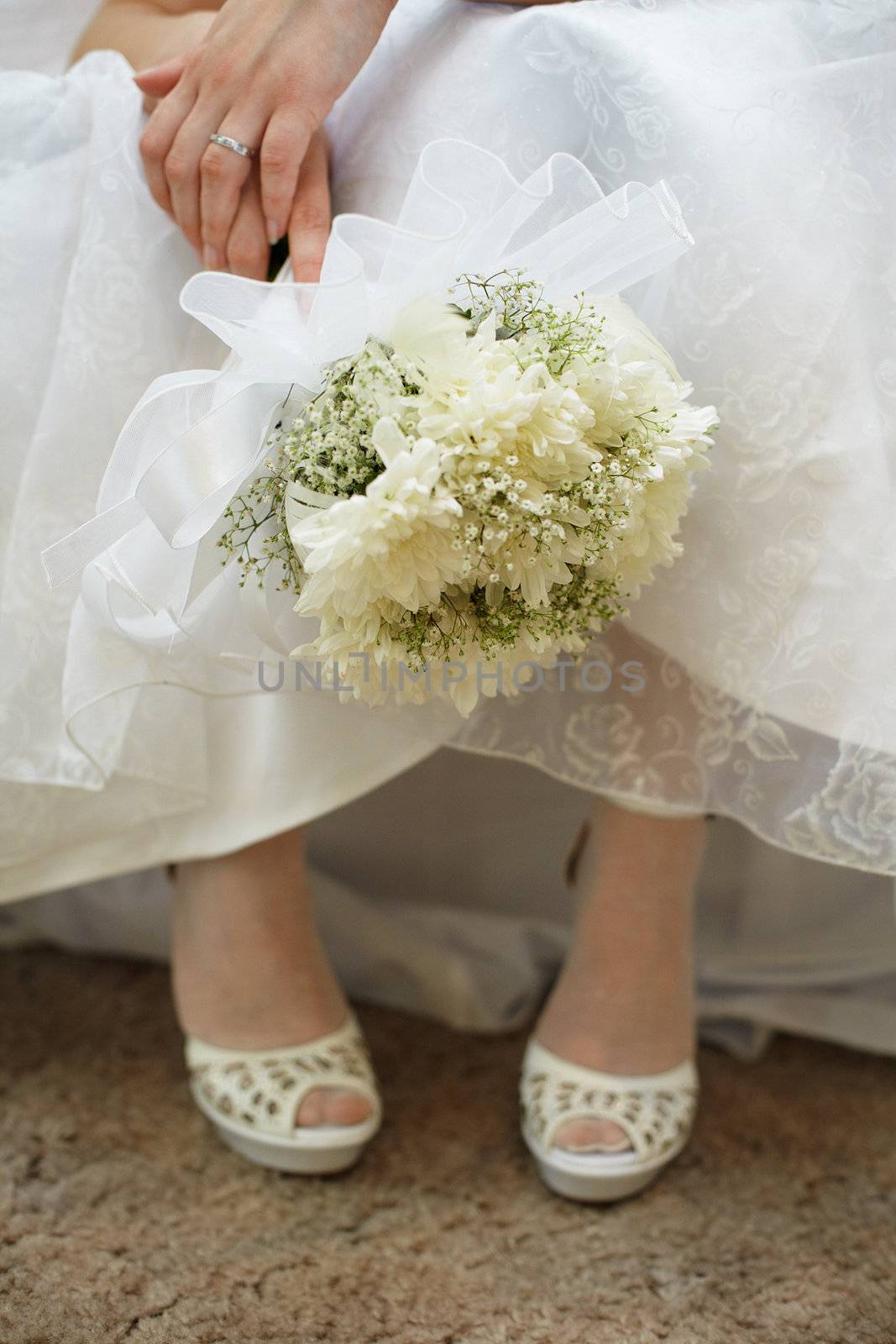 Bouquet of the bride against a dress and shoes