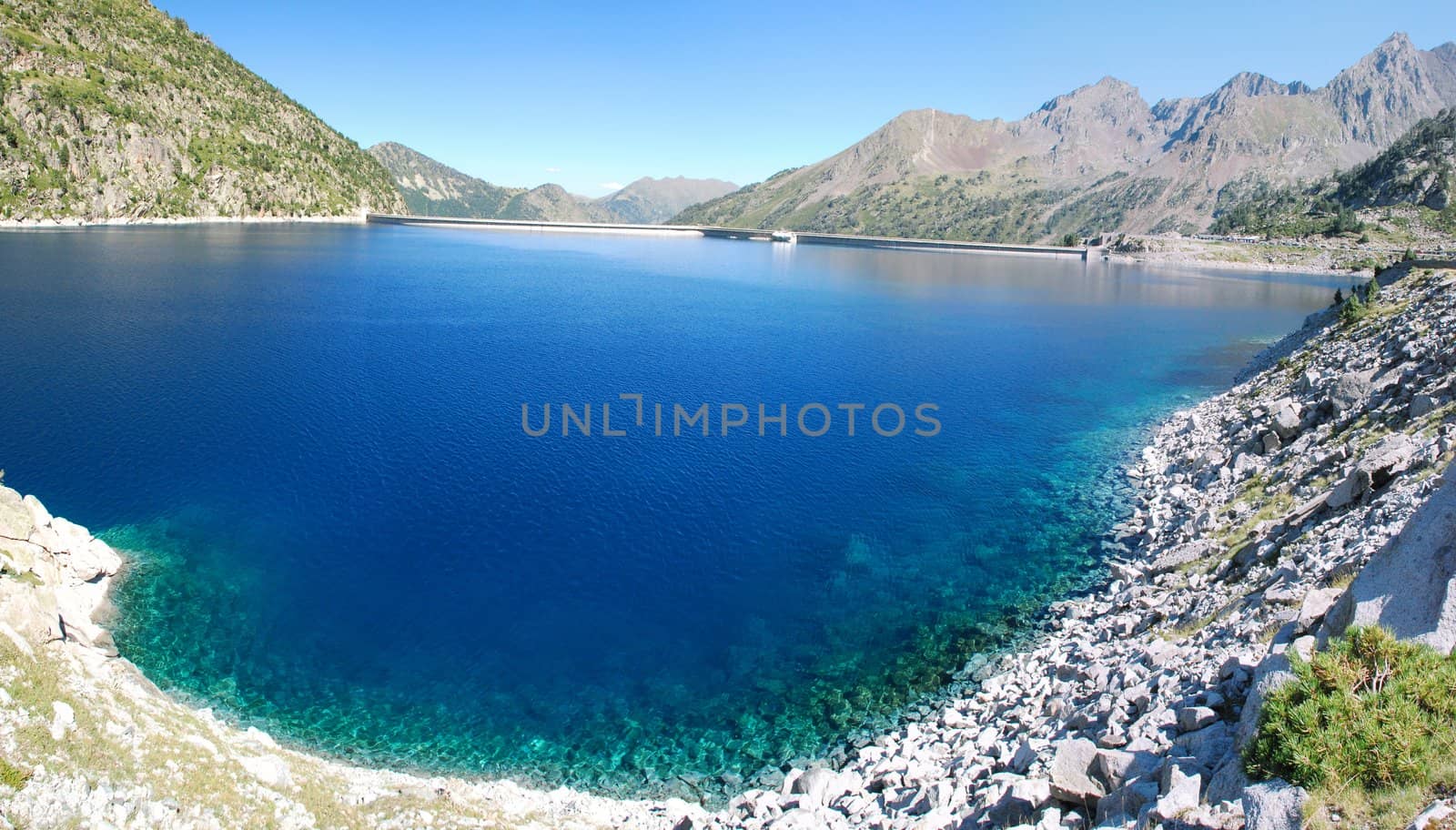 The pure and transparante water of Lake Cap-de-Long  in French Hautes-Pyrenees, At an elevation of 2161 m its 130 deap. Its created by grate dam used for hydroelectric energy station. In the and is a grandiouse dam