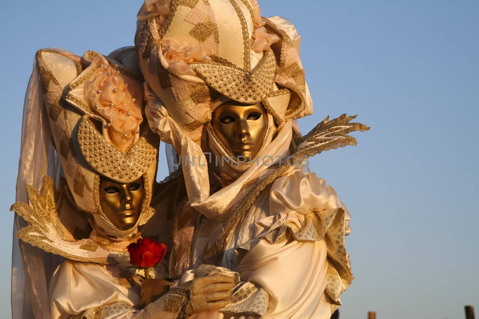 A masked couple in love, a rose in hand, during the Venice Carnival