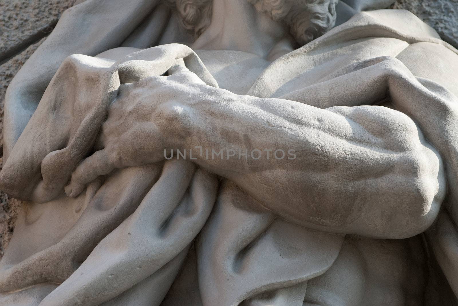 a detail of a statue showing a hand holding a towel