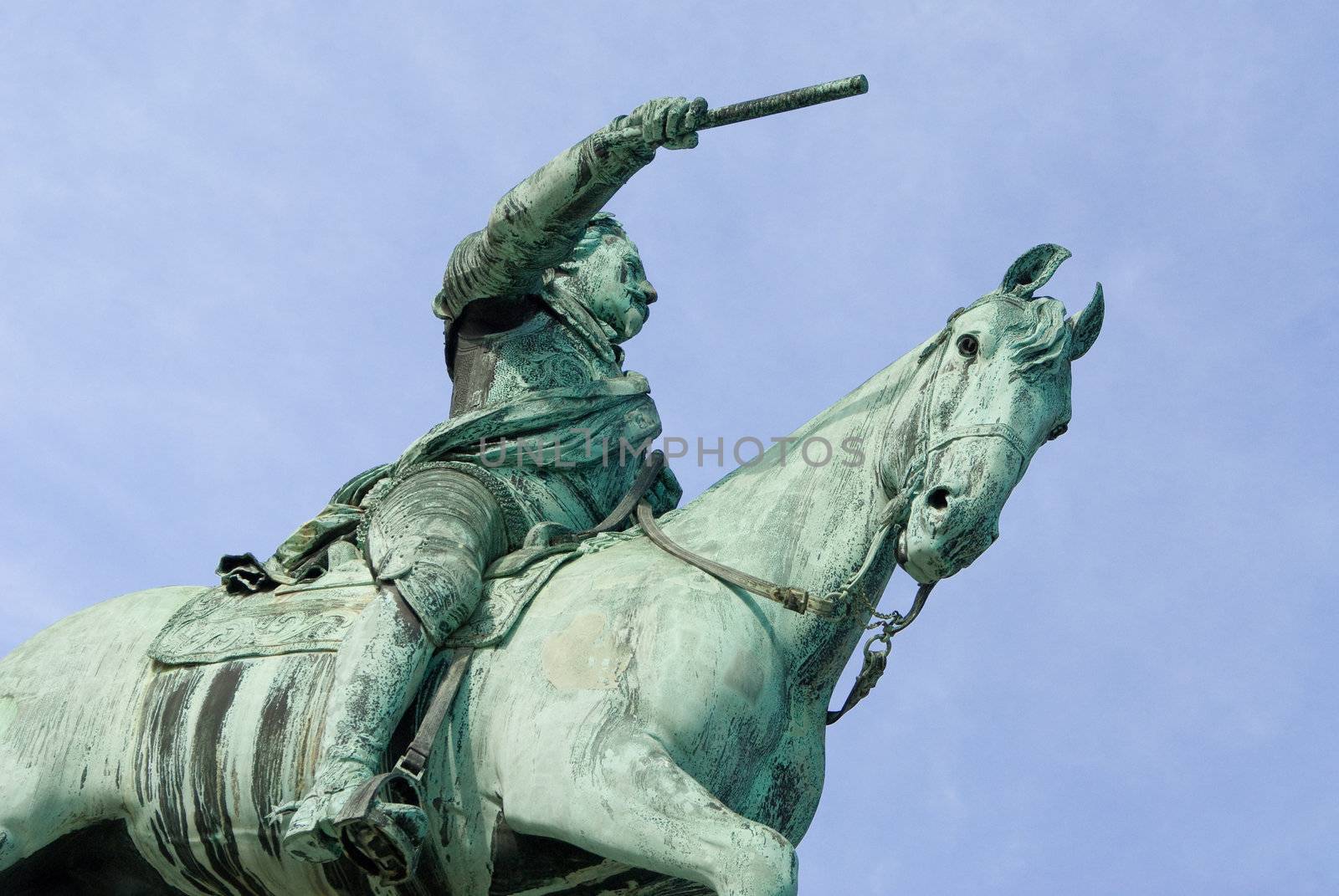 a statue of a leader riding on a horse pointing with a stick