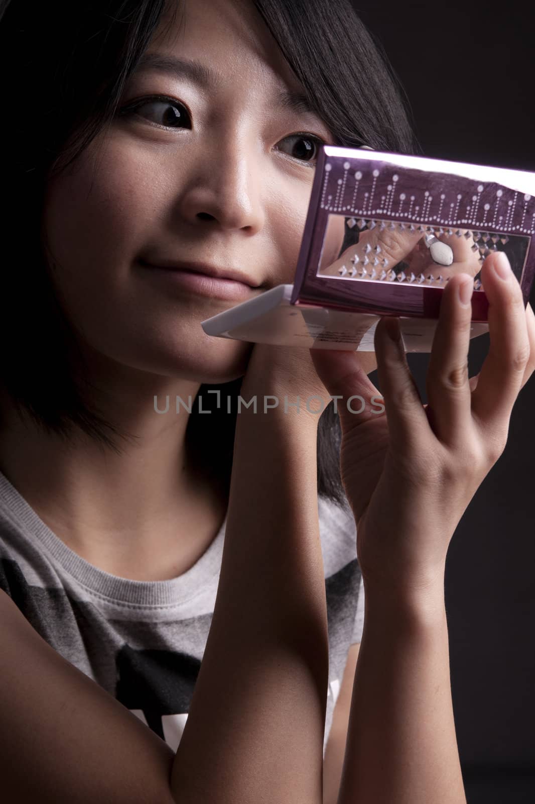 a young fashionable asian girl applying eye shadow and make-up