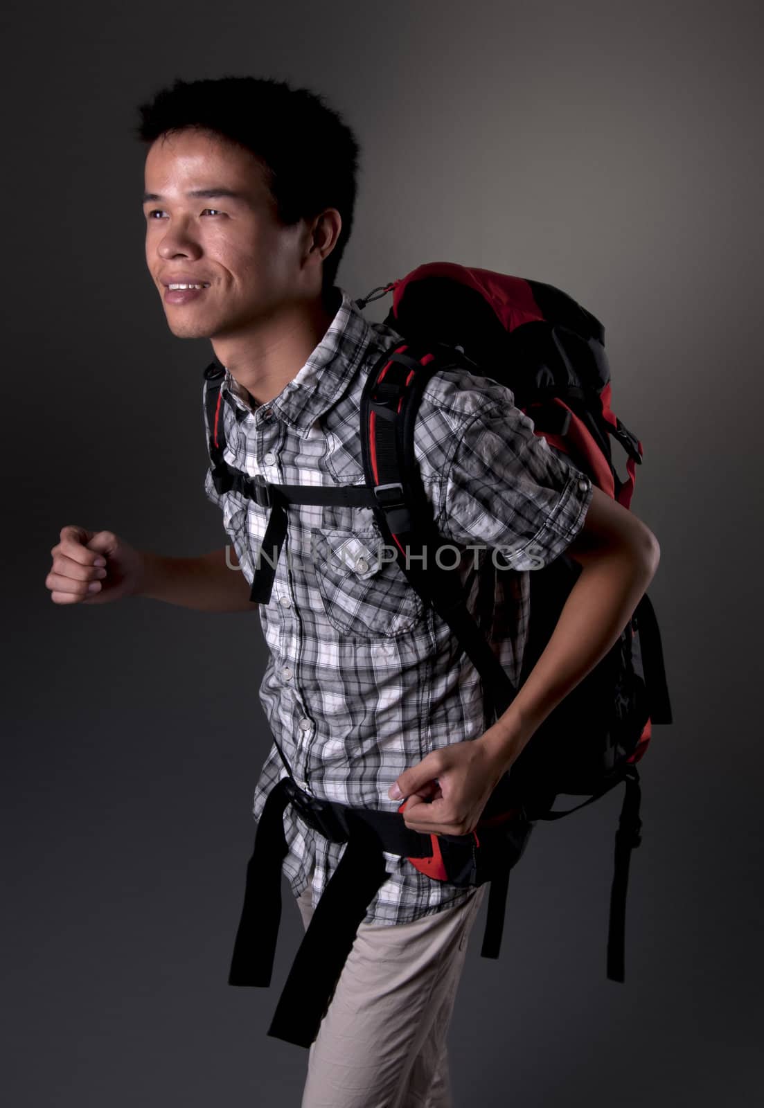 Asian man excited about hiking in the outdoors wearing backpack