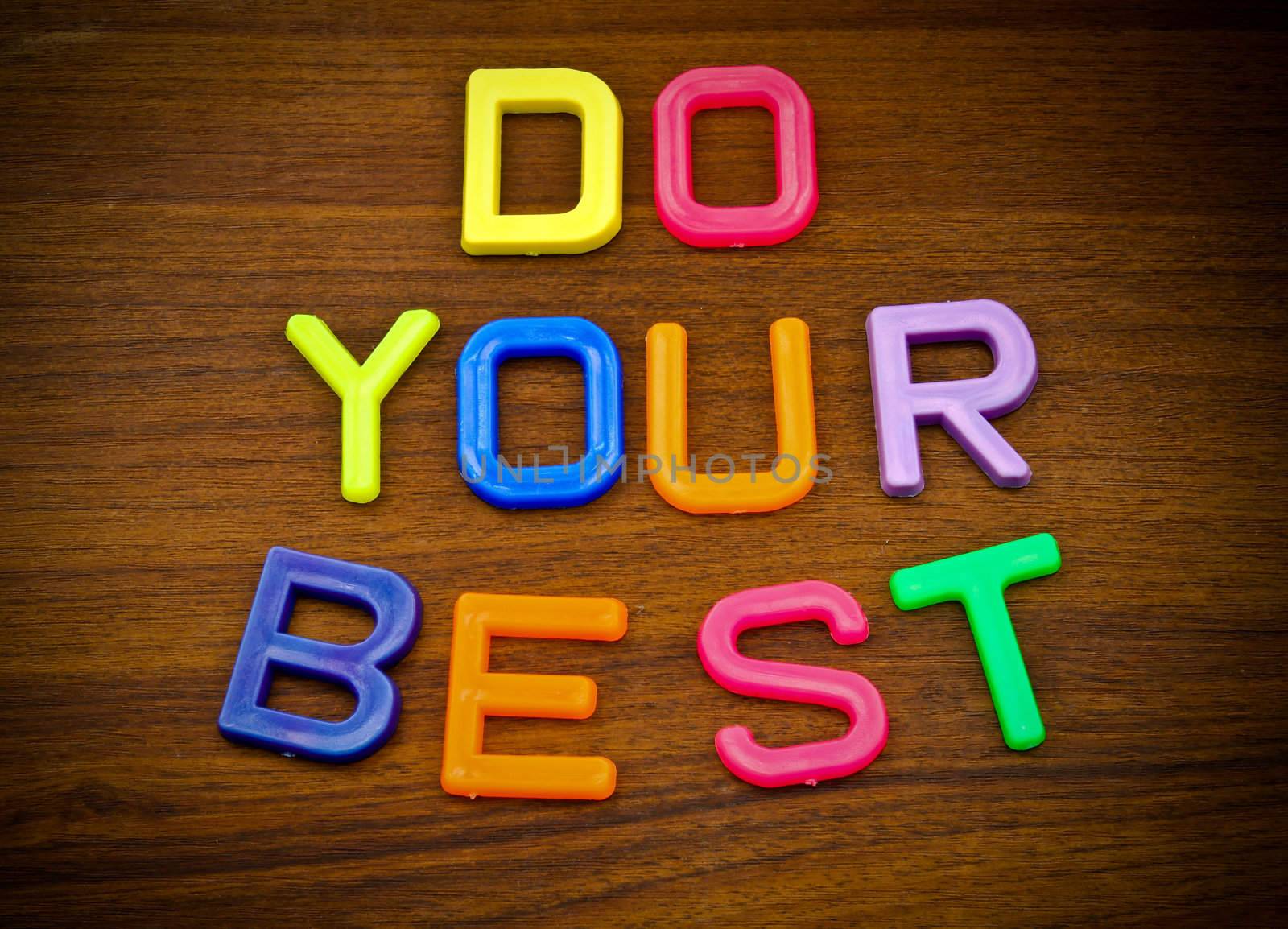 Do your best in colorful toy letters on wood background by nuchylee