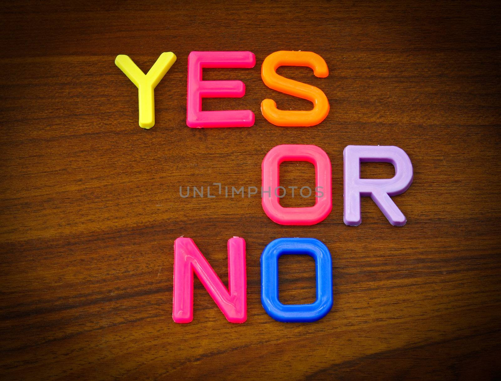 Yes or no in colorful toy letters on wood background