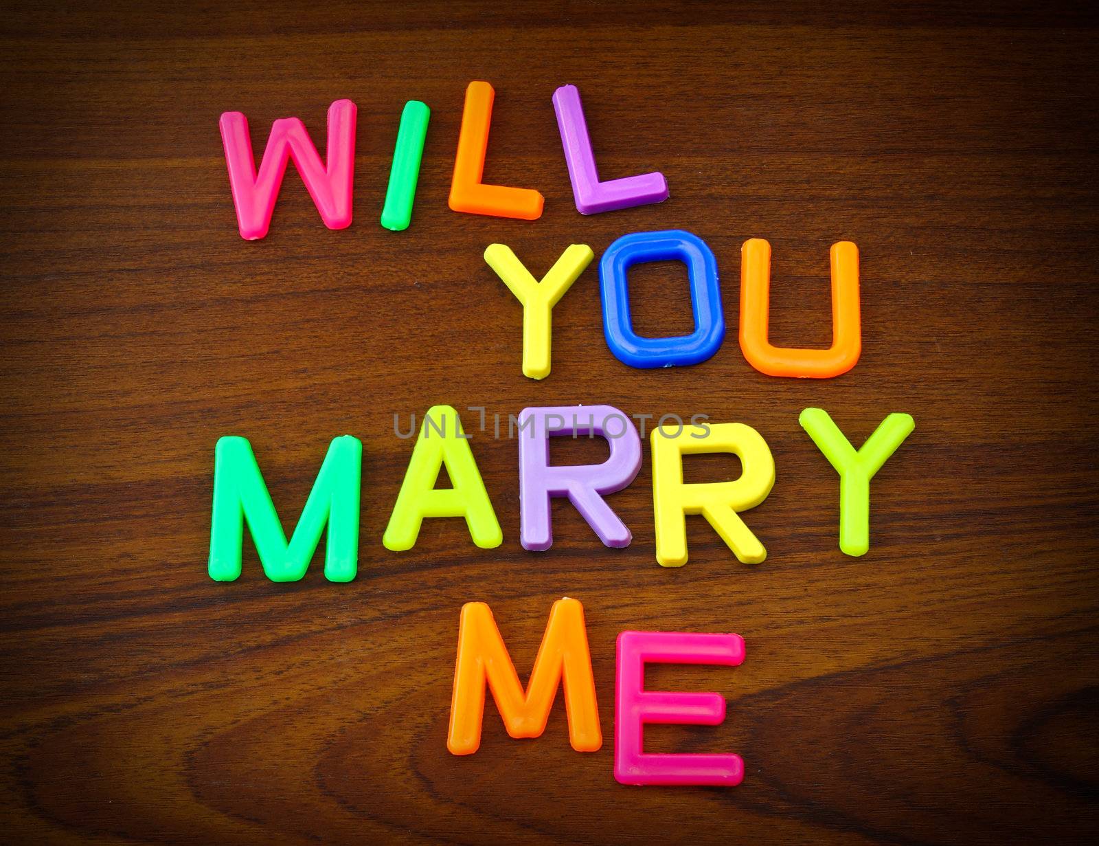Will you marry me in colorful toy letters on wood background by nuchylee