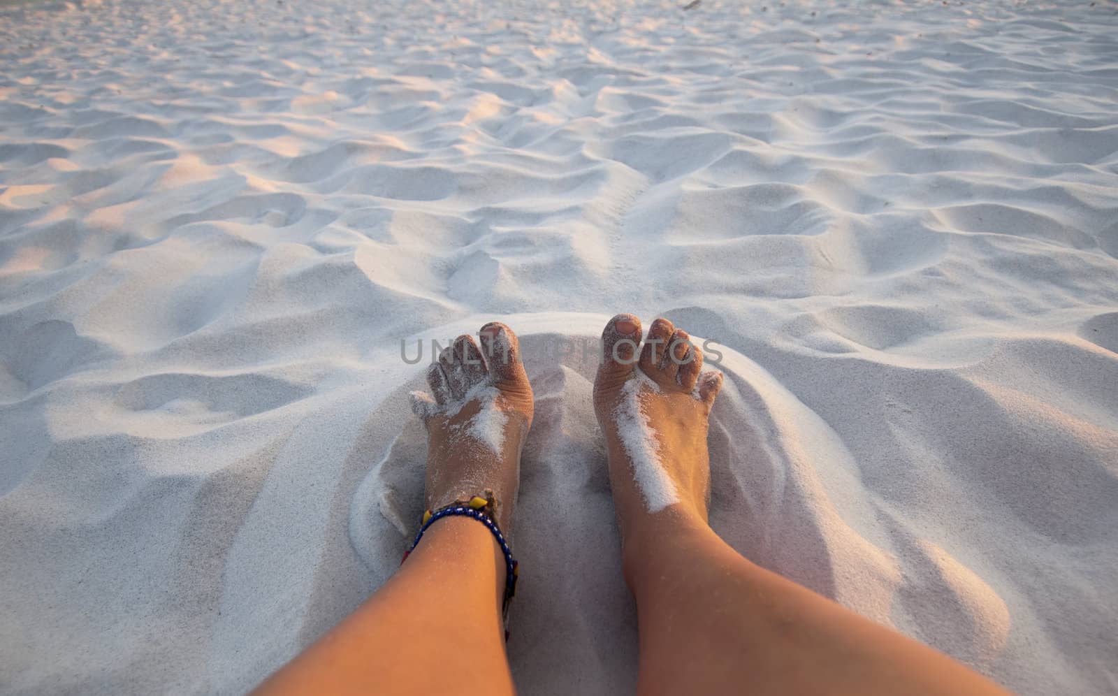 Feet playing in the sand on a white sand beach
