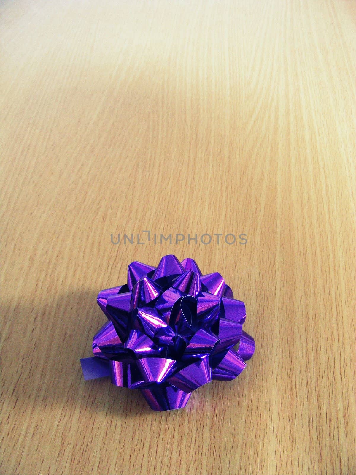 A photograph of a purple tinsel gift decoration.