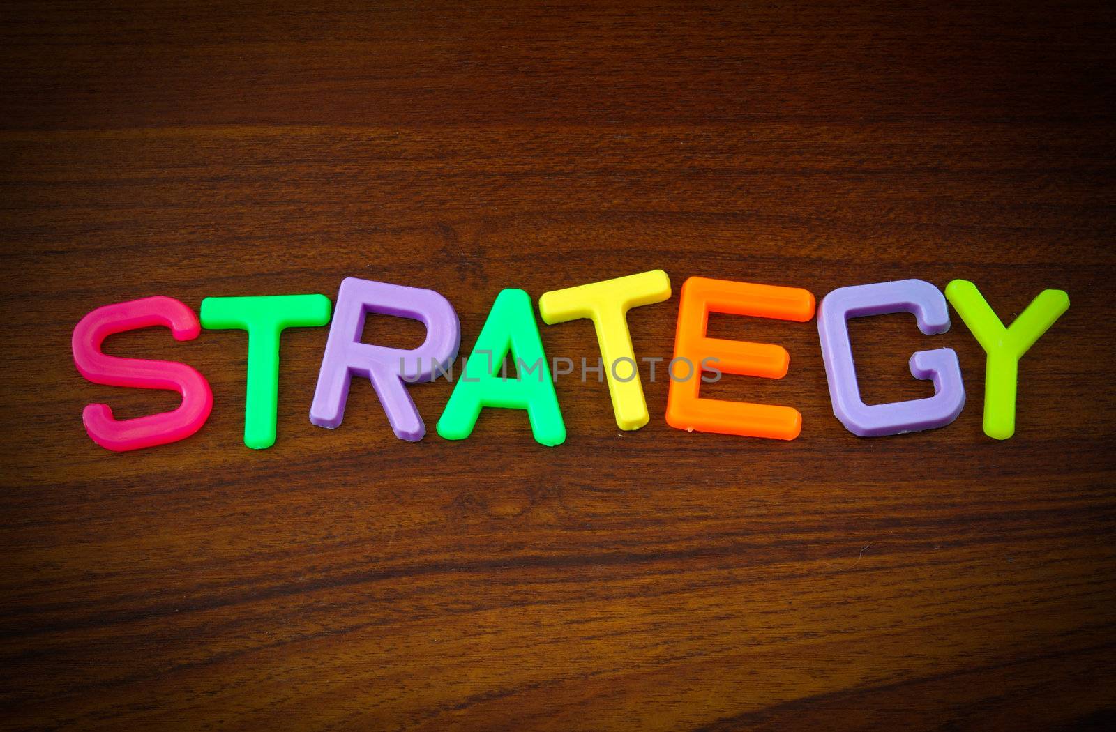 Strategy in colorful toy letters on wood background  by nuchylee
