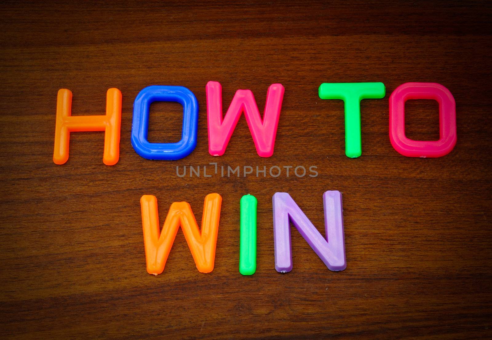 How to win in colorful toy letters on wood background