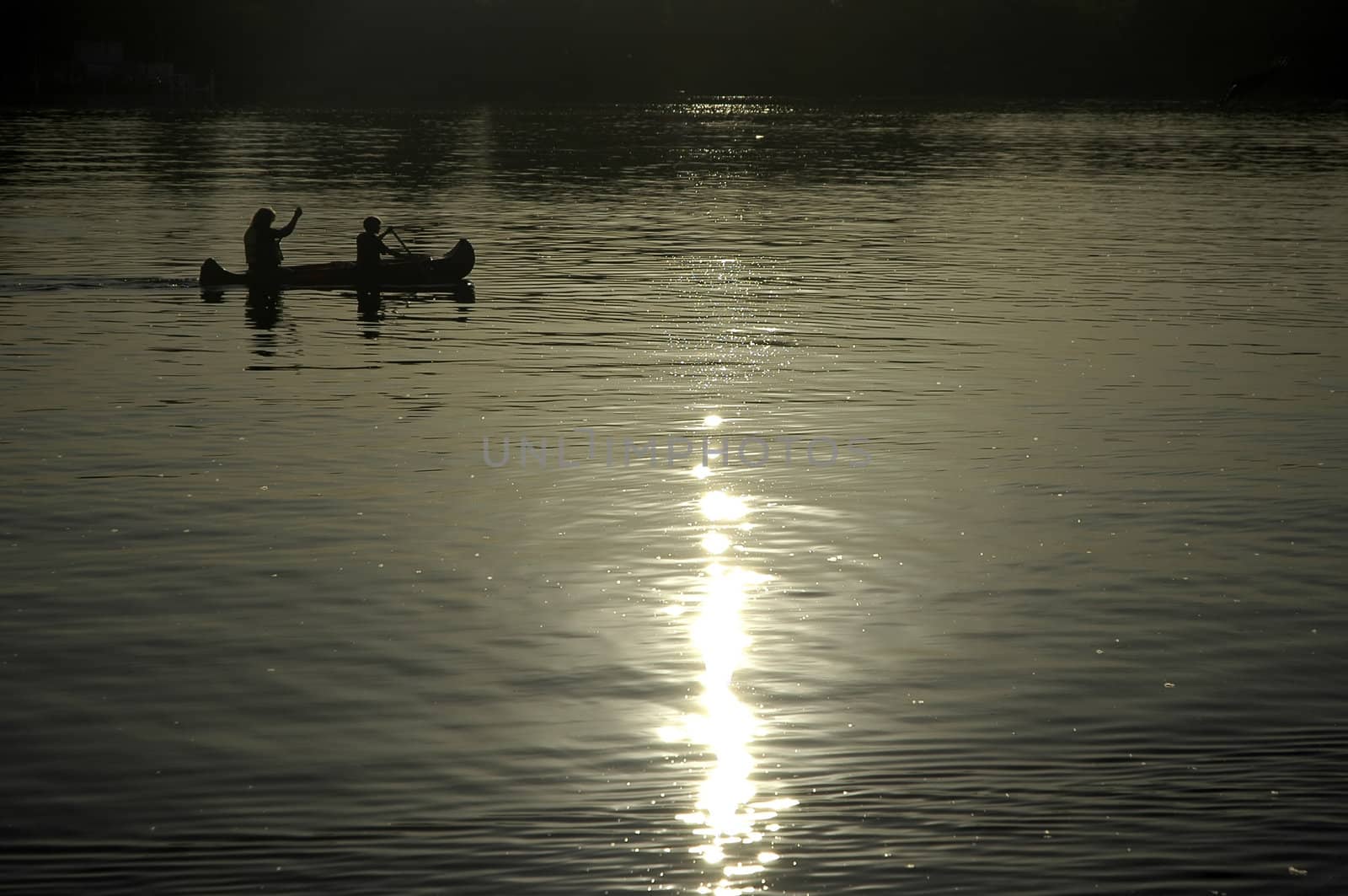 boy and his mother paddling on a kayak, reflection in water